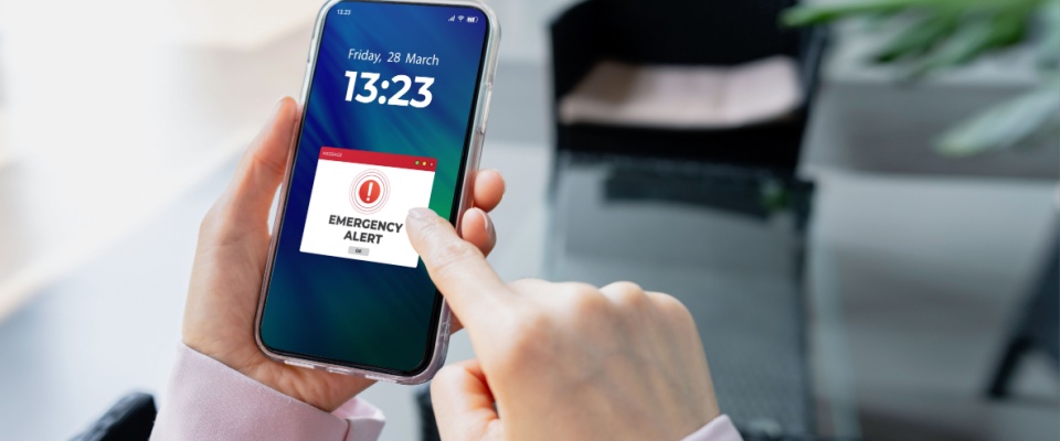 Am "emergency alert" message displayed on the screen of a smartphone to illustrate a key security feature for renters in downtown apartments.