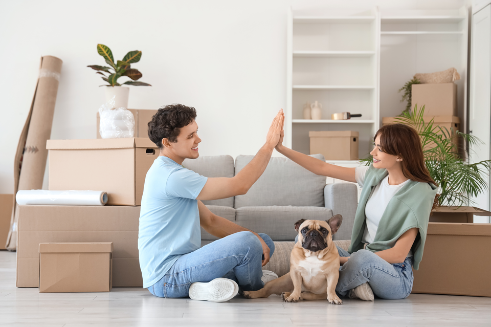 happy couple moved in a new apartment with dog