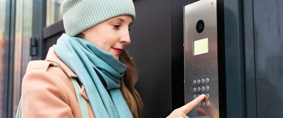 A woman entering a code on a keypad for access as a key security feature for downtown apartments.