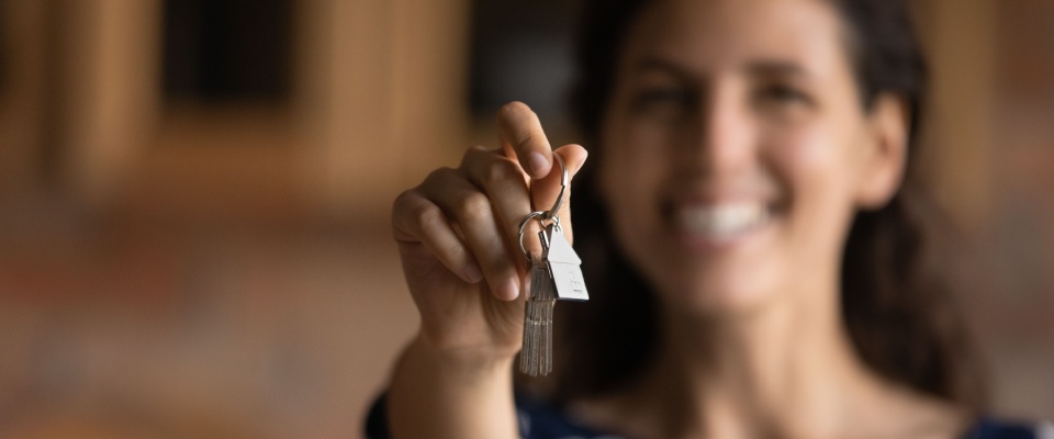 A person holding keys to a rental apartment after signing the lease renewal agreement.