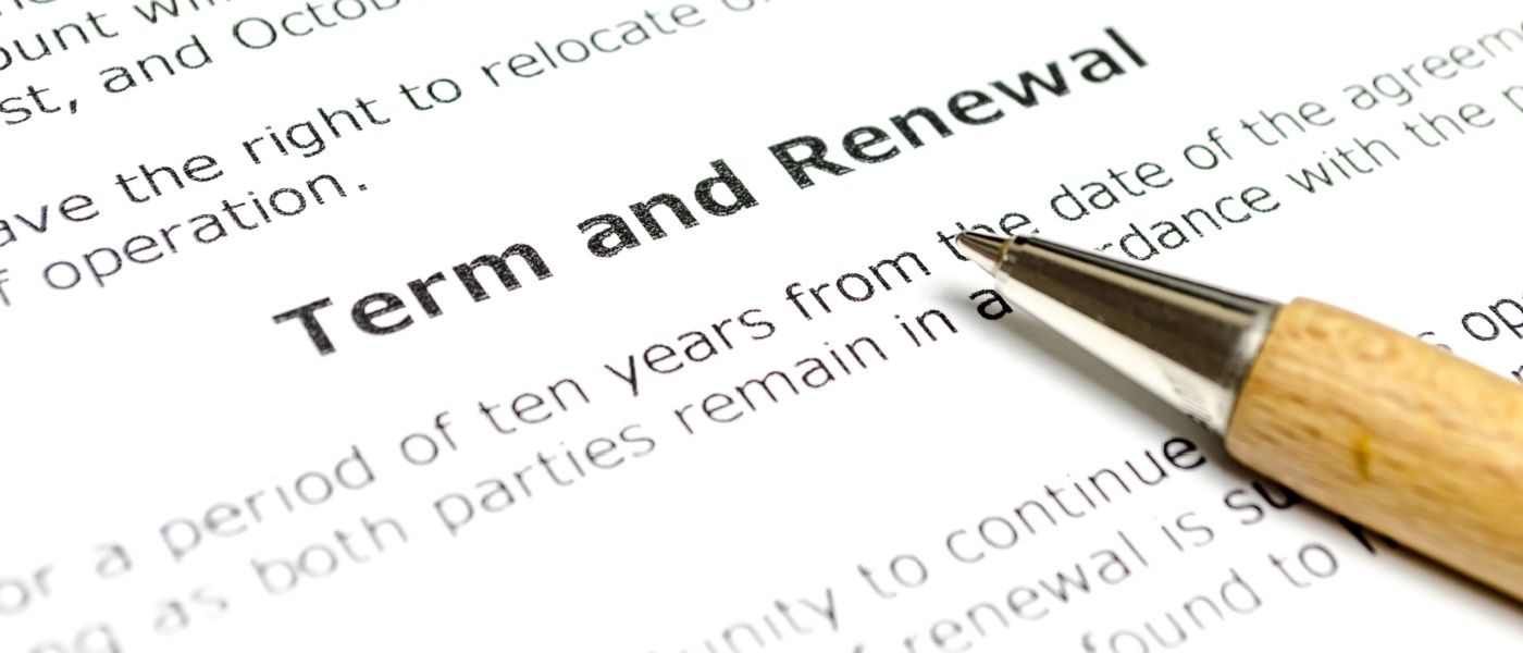 A photo of a pen resting on a lease renewal agreement.