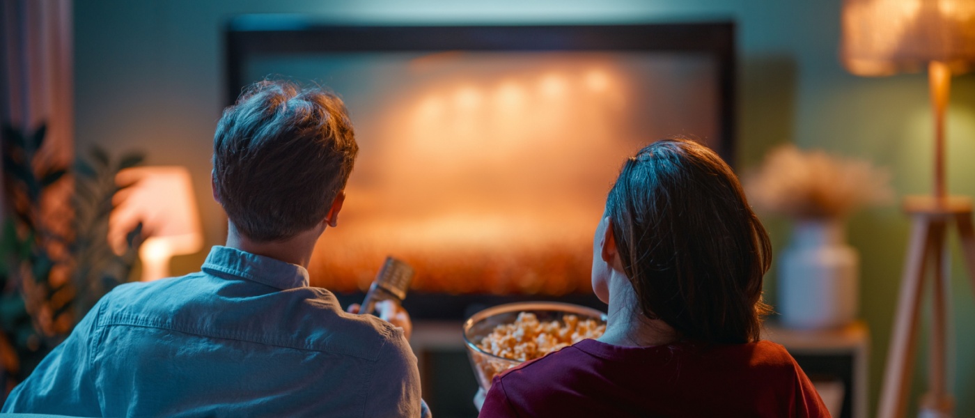 A couple enjoying a movie in an apartment community media room.