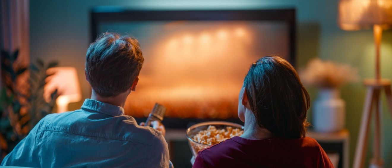 A couple enjoying a movie in an apartment community media room.