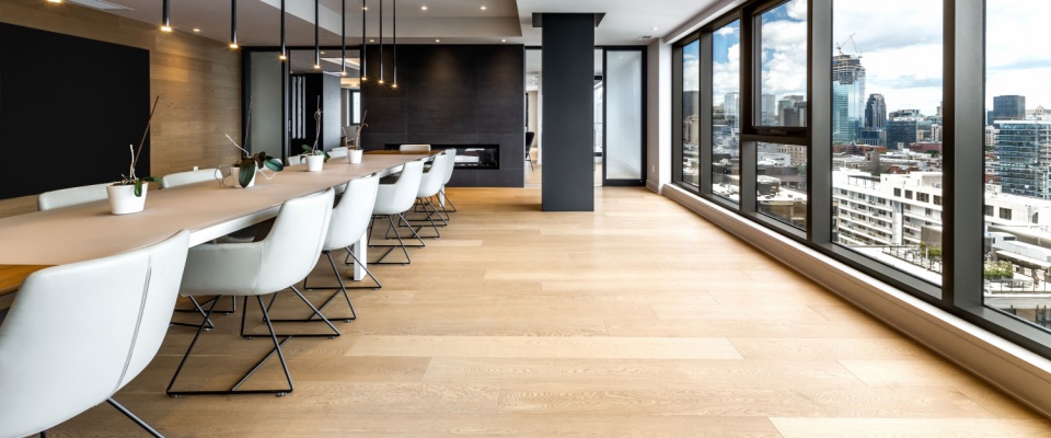 Modern apartment building in Montreal’s Griffintown with shared amenities including club rooms, reception areas, patio spaces, and city views.