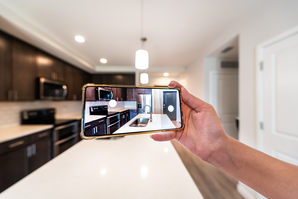 person taking picture of kitchen appliances before moving in rental apartment