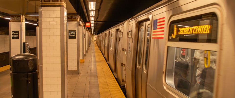 Interior of a subway station platform in New York, USA. Subway train running in Canal St. station with soft warm lighting to illustrate the connections of public transport in Yonkers, NY.