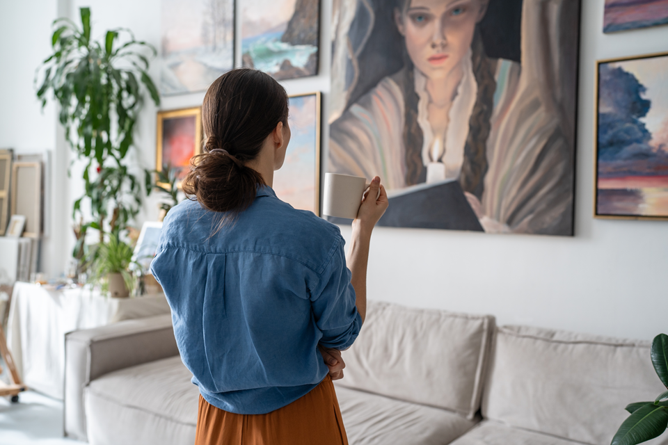 person looking at paintings in her apartment