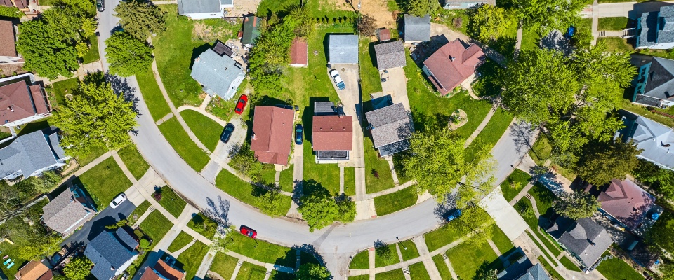 Aerial view of a circular suburban neighborhood with homes and streets during summer, representing residential communities and apartments in El Paso.