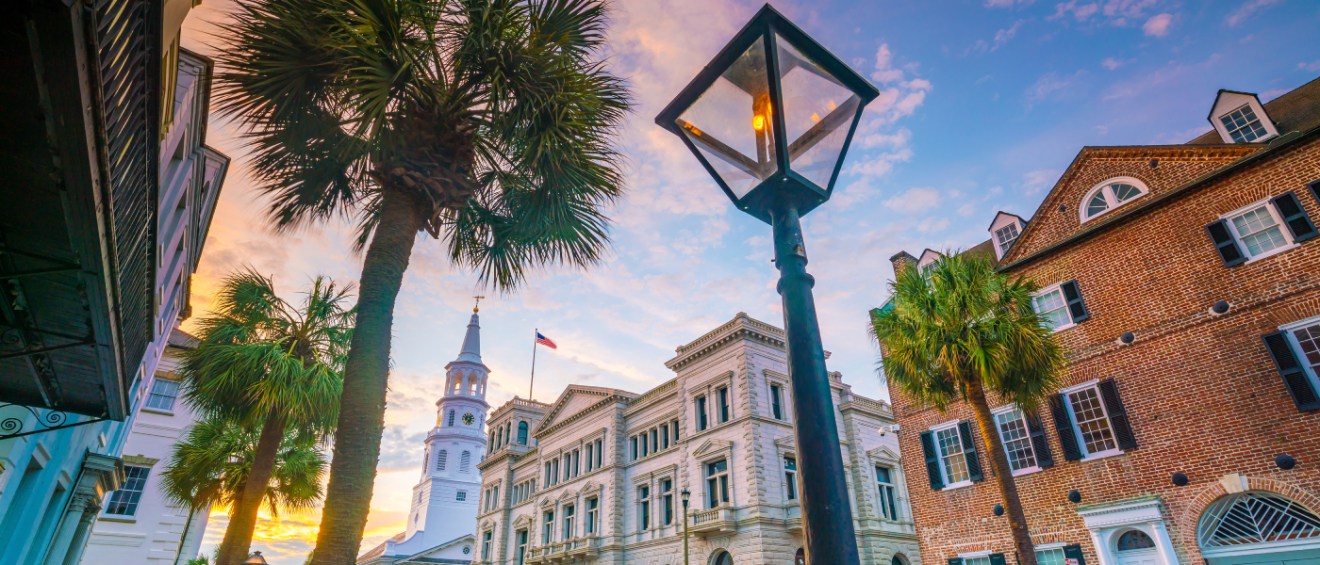 A dusk-time photo of the historic downtown area in Charleston, SC, a city where renters can find neighborhoods with prices below the city average.