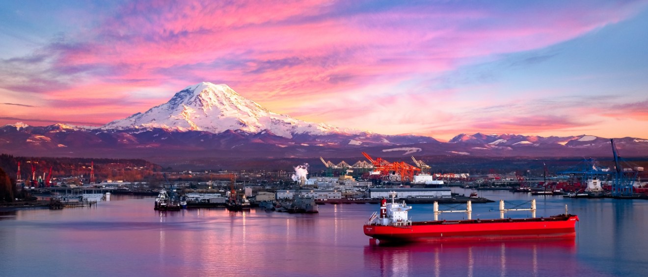 A waterfront view of Tacoma, WA, a city where renters can find affordable neighborhoods with below-average rents, with Mt. Rainier behind it.