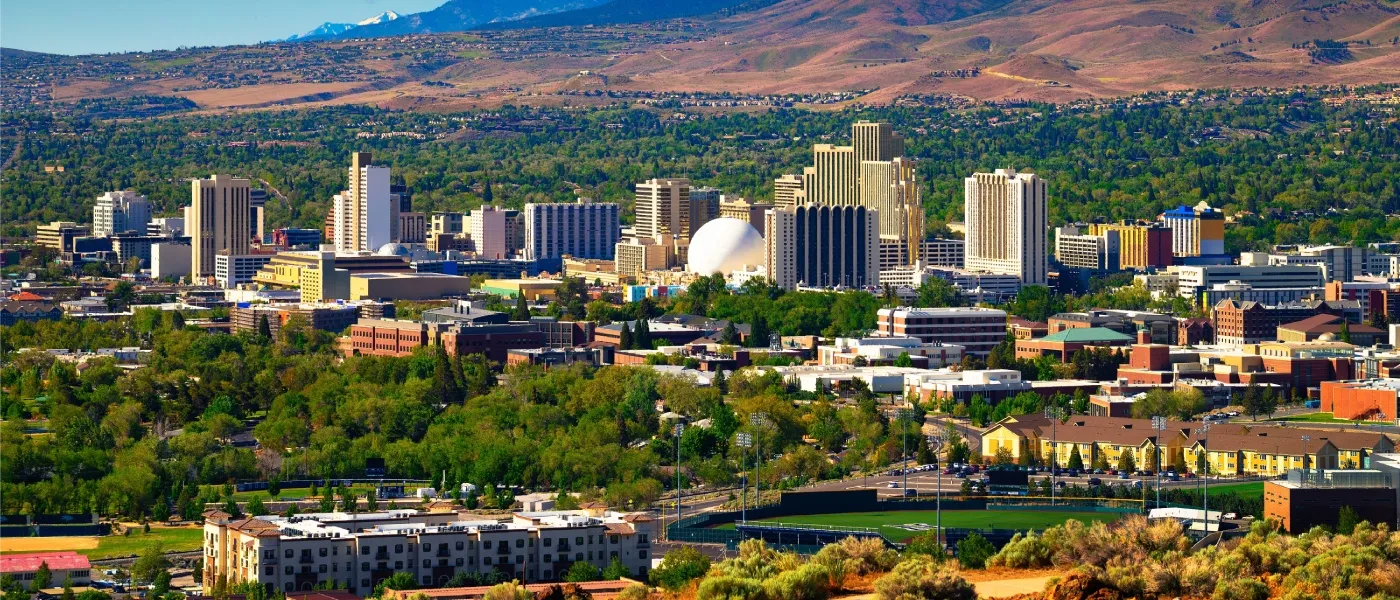 Apartments in Reno highlighted by the downtown Reno skyline with hotels, casinos, and the Eastern Sierra foothills in the background.
