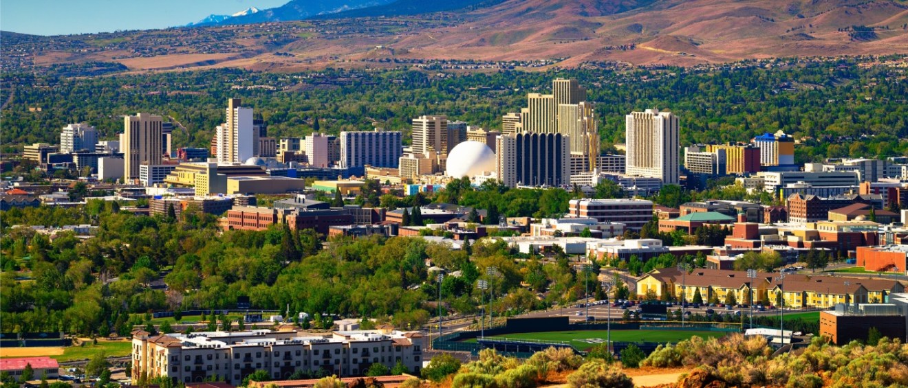 Apartments in Reno highlighted by the downtown Reno skyline with hotels, casinos, and the Eastern Sierra foothills in the background.