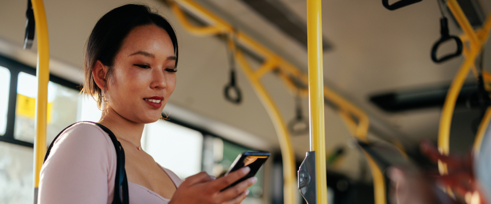 A person checking their phone while using public transit in Sarasota, FL.