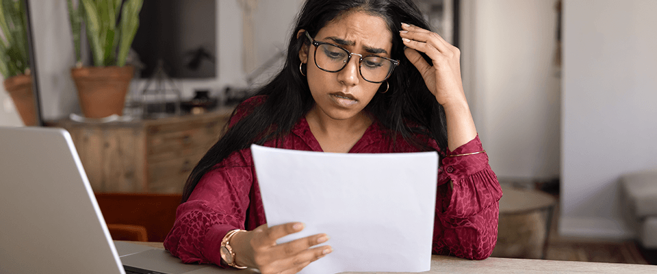 Frustrated young woman wearing glasses while reading bad news in legal documents, illustrating stress after a rental application rejected decision.