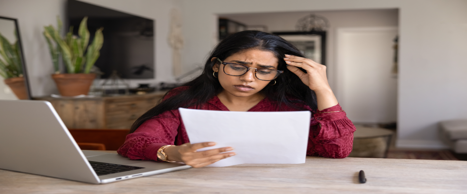 Frustrated young woman wearing glasses while reading bad news in legal documents, illustrating stress after a rental application rejected decision.