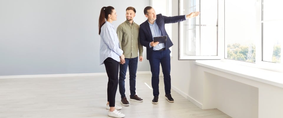 A property manager conducting an in-person tour for renters interested in an apartment to illustrate the pros and cons of virtual tours.
