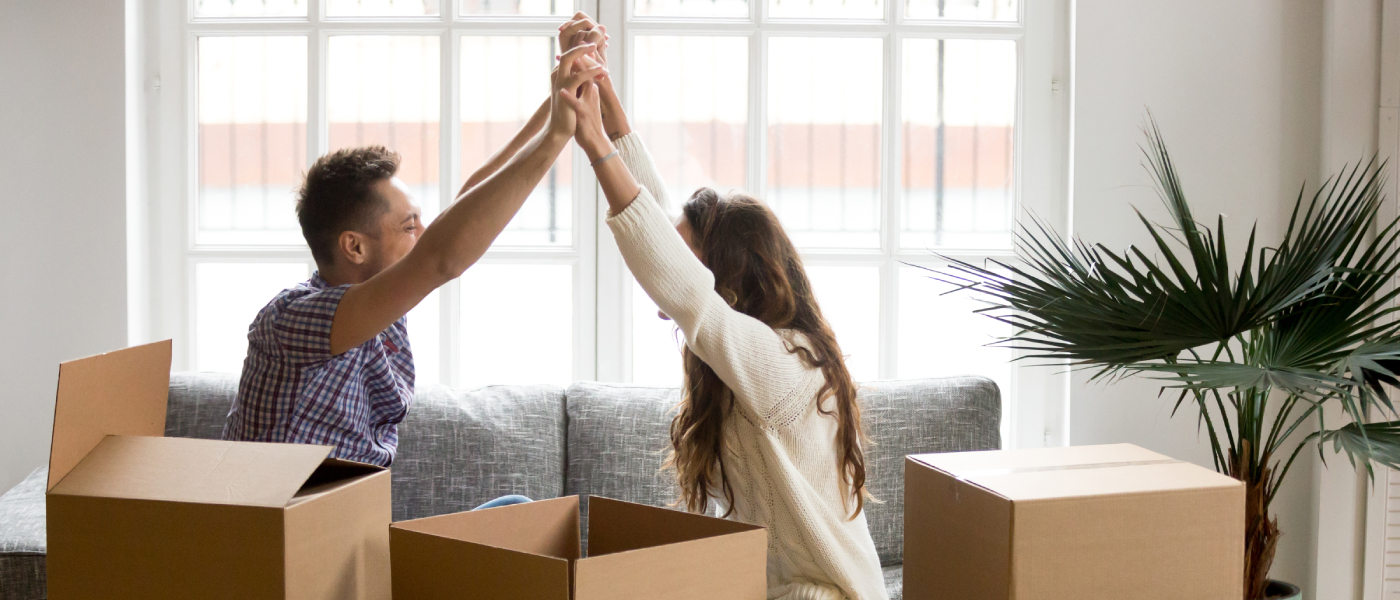 Couple in a bright apartment living room. Cost of living comparison for renters evaluating housing options and affordability in Miami vs. Tampa, FL.