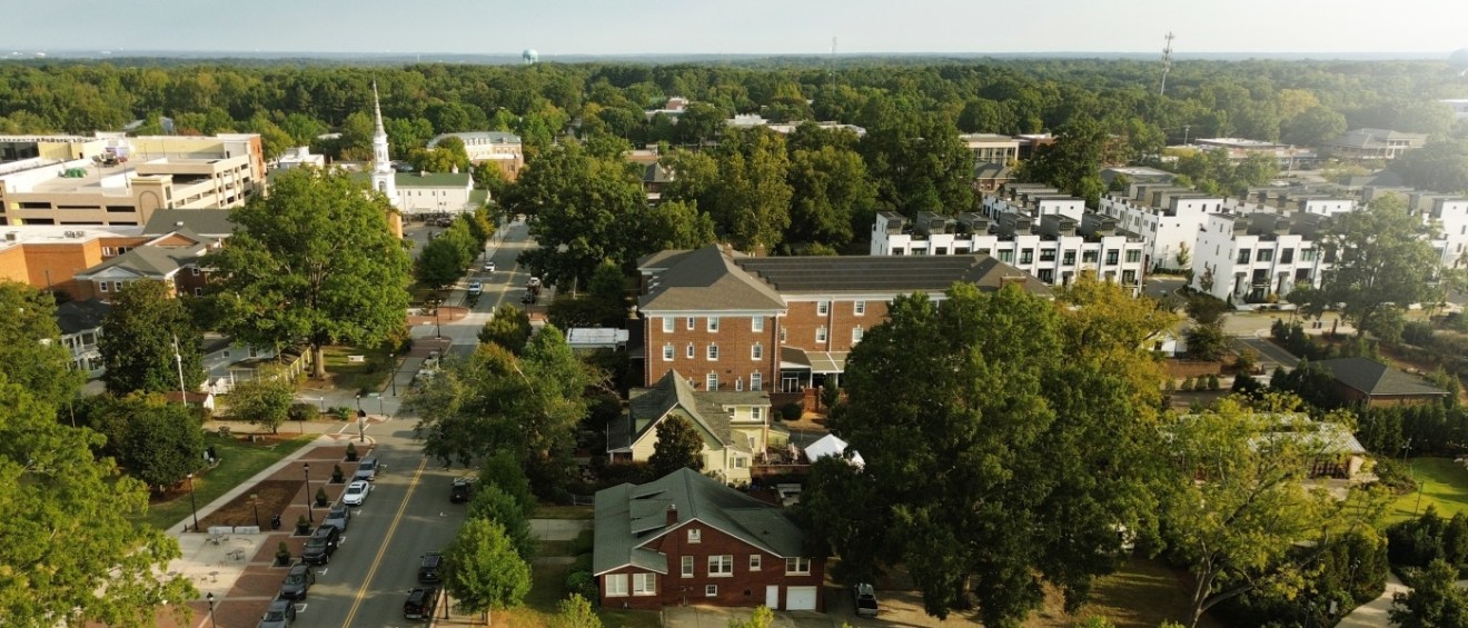 Aerial view of Academy Street and Downtown Cary Park in Cary, North Carolina, representing affordable neighborhoods with community amenities, green spaces, and convenient access to local attractions.