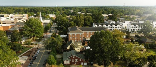 Aerial view of Academy Street and Downtown Cary Park in Cary, North Carolina, representing affordable neighborhoods with community amenities, green spaces, and convenient access to local attractions.