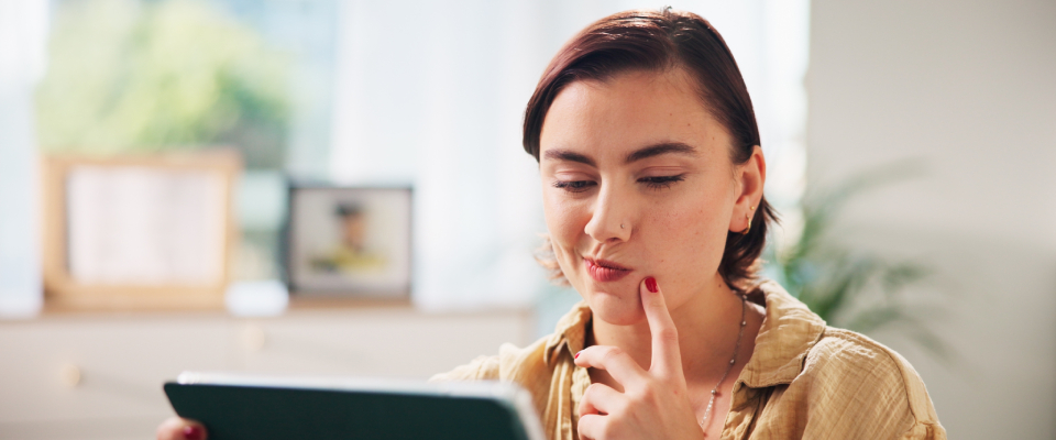 A person using a tablet during an apartment search for a job promotion.