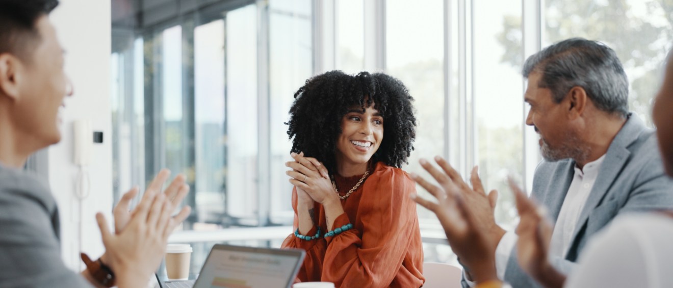 A person being congratulated by their coworkers after being promoted.