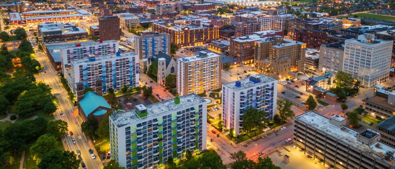 Aerial dusk view of affordable neighborhoods in St. Louis, MO featuring mid-rise apartment buildings and tree-lined streets.