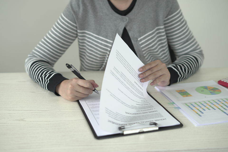 woman signing a rental agreement for a new home