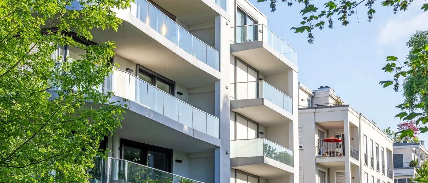 Modern apartment buildings surrounded by green spaces, illustrating the right neighborhood for a young professional seeking convenience, amenities, and quality of life.