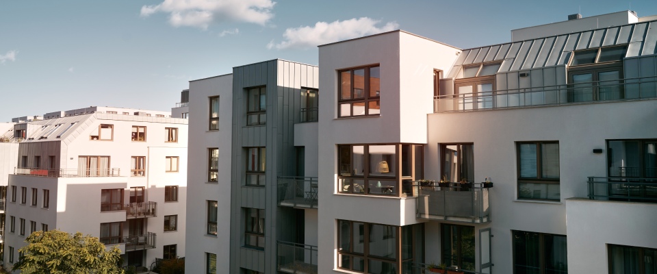 Modern European apartment complex with landscaped outdoor amenities, illustrating the type of community and convenience found in the right neighborhood for a young professional.