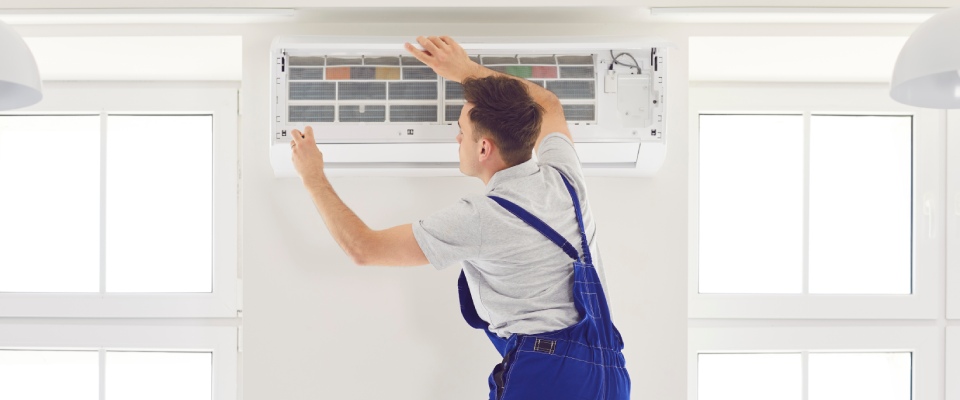 HVAC technician inspecting and maintaining a residential air conditioning system, highlighting reliable maintenance services and climate-controlled comfort in apartments in Surprise.