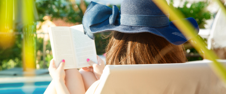 A person reading a book and following apartment pool rules.