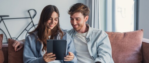 A couple using a tablet when apartment searching.