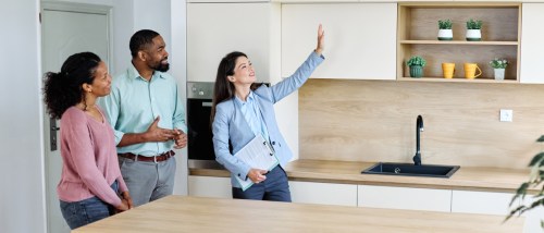 A couple and a realtor during an apartment tour, checking for red and green flags.