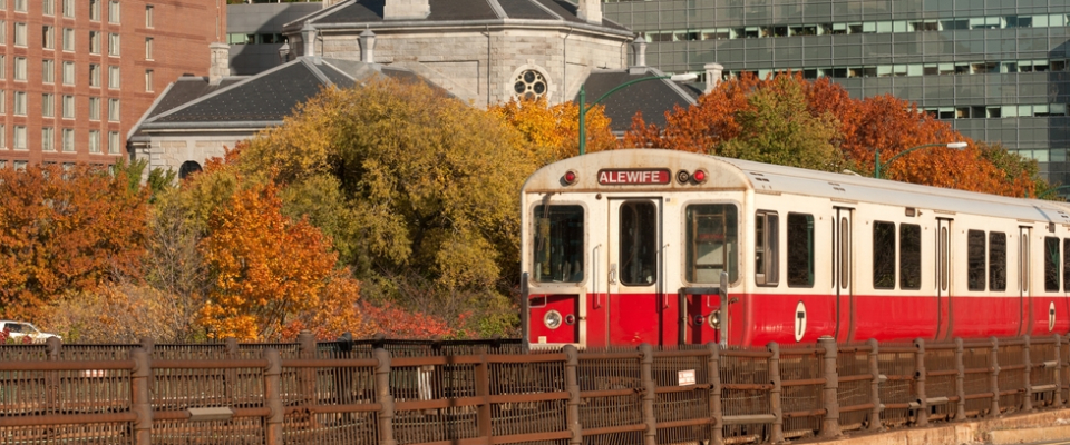 MBTA Red Line train bound for Alewife passing fall foliage, showing why transit access matters when renting in Boston.