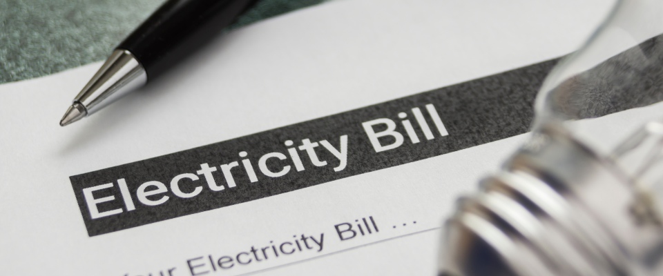 Electricity bill, pen, and desk lamp on a table, highlighting household expenses and budgeting considerations for apartments in McAllen.