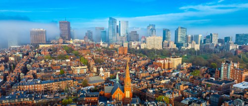 Aerial view of Boston's brick rowhouses and downtown skyline, illustrating what to consider when renting in Boston.