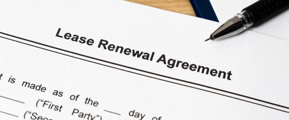 Close-up of a residential lease agreement and renewal document with a pen, representing rental opportunities and leasing processes for apartments in Santa Barbara.