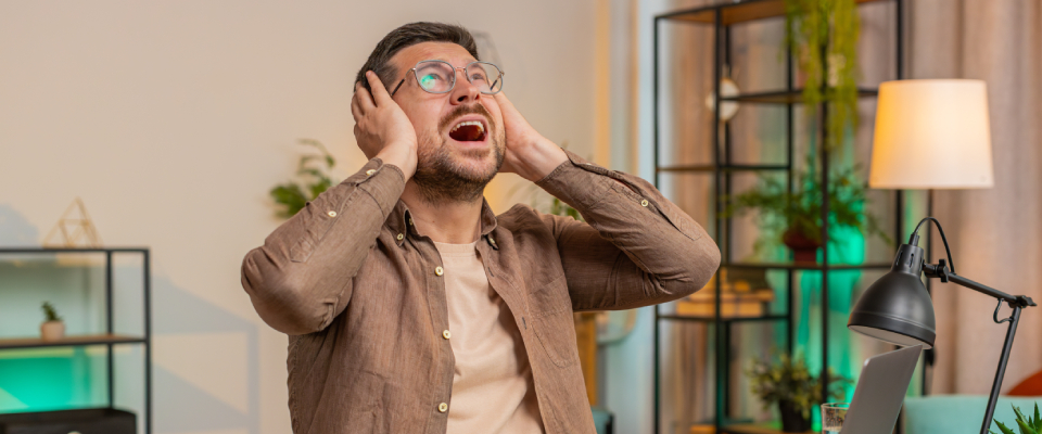 A person frustrated by noise while working from home with roommates.