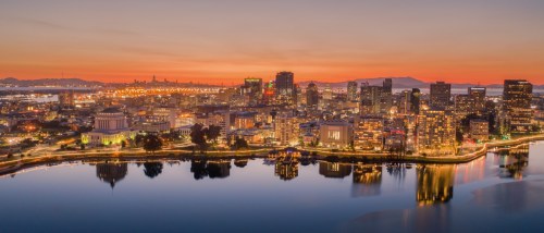 Aerial view of the Oakland skyline at sunset, highlighting the city's urban landscape and affordable neighborhoods for renters.