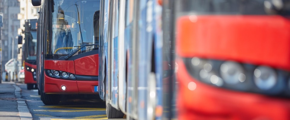 Public transportation bus traveling through an urban neighborhood, illustrating convenient public transit for daily commuting and city travel.