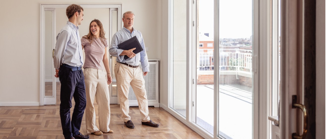 A couple on an apartment tour looking at how much natural light the orientation allows.
