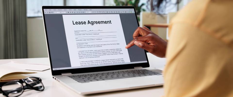 Woman signing an online lease contract for renting real estate property at home related to a co-sign agreement.